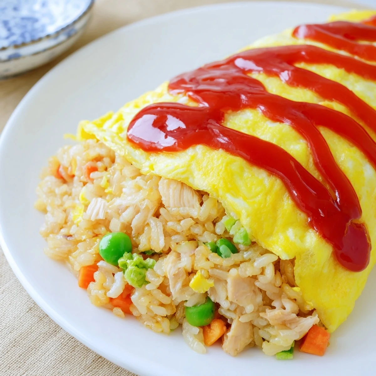 Golden fluffy omelet wrapped around savory tomato fried rice drizzled with ketchup