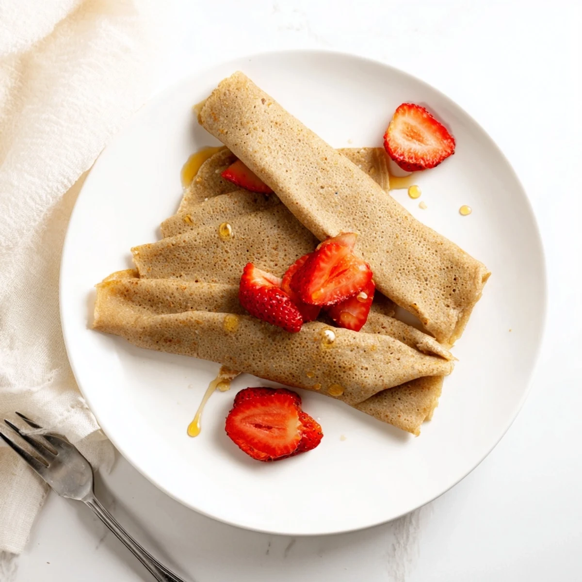 Wholesome oatmeal crepe being lifted from skillet showing delicate golden brown spotted surface