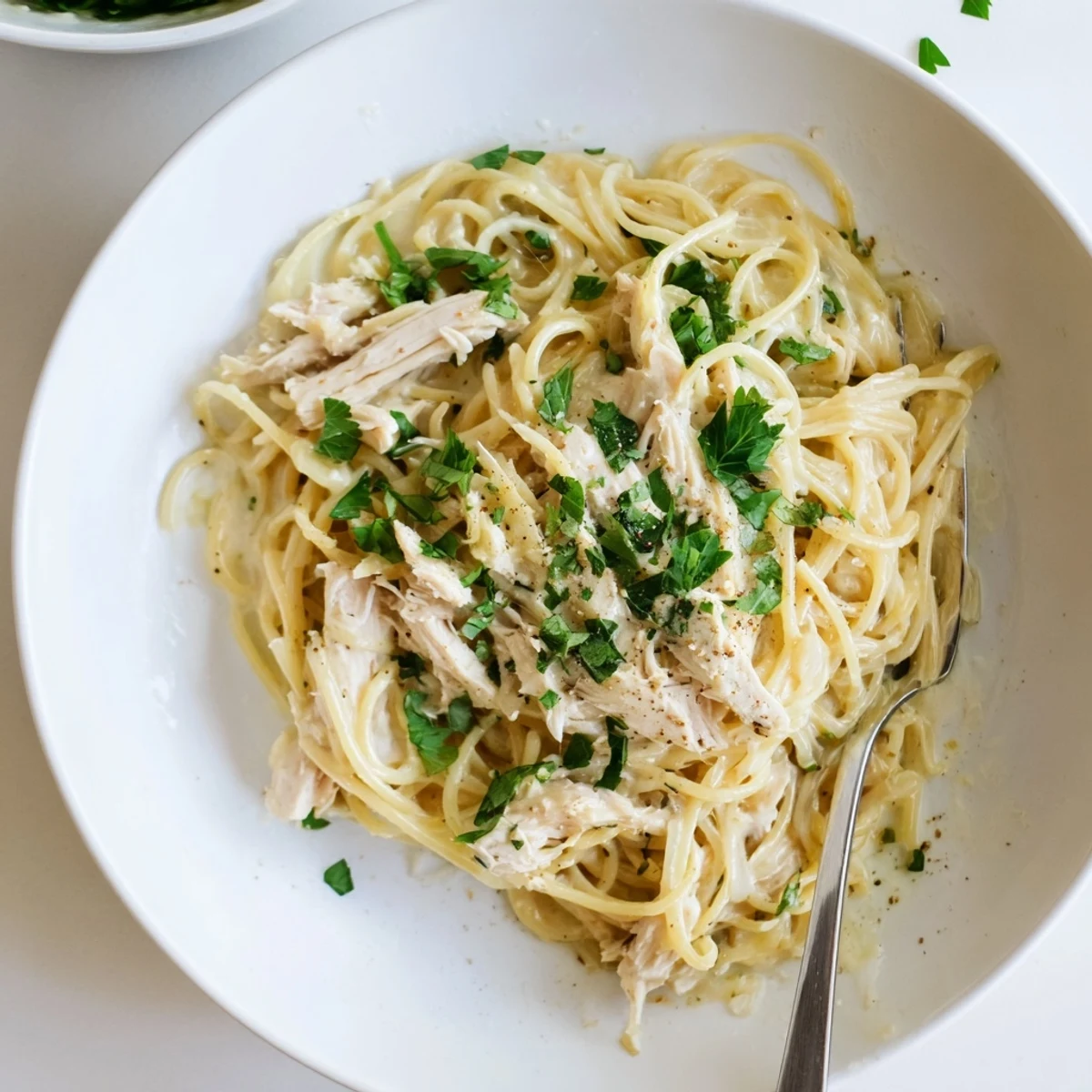 Creamy Crock Pot Angel Chicken draped over tender angel hair pasta with golden sauce