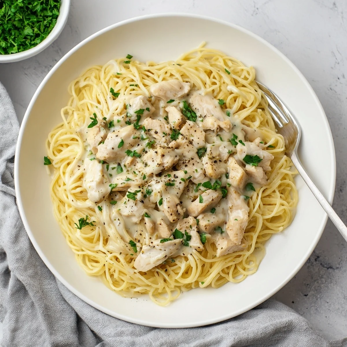 Golden Crock Pot Angel Chicken with melted cream cheese sauce over white pasta