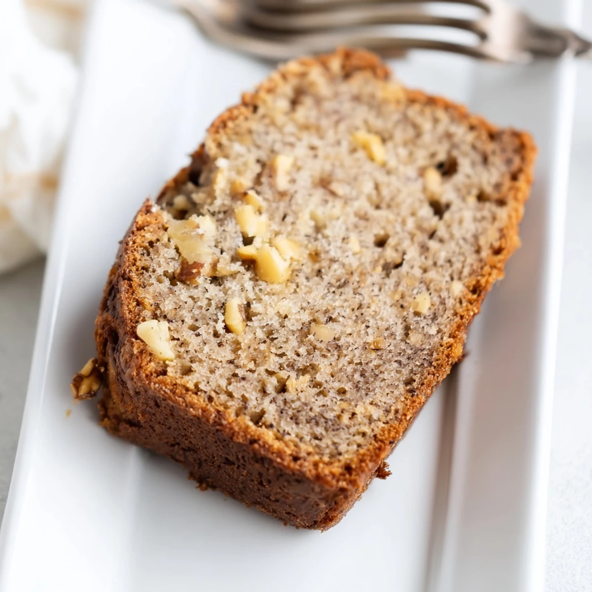 Moist low carb banana bread with walnuts baked in a parchment lined loaf pan