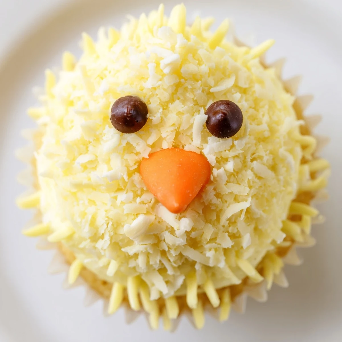Adorable Easter Chick Cupcakes with fluffy yellow frosting and candy faces on white serving platter