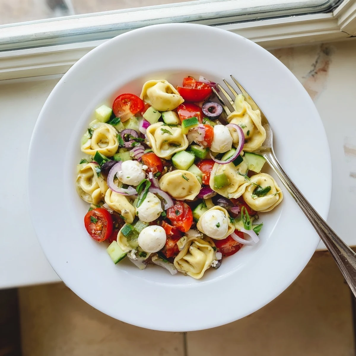 Cheese-filled tortellini pasta salad tossed with ripe tomatoes, crisp cucumber, and tangy vinaigrette