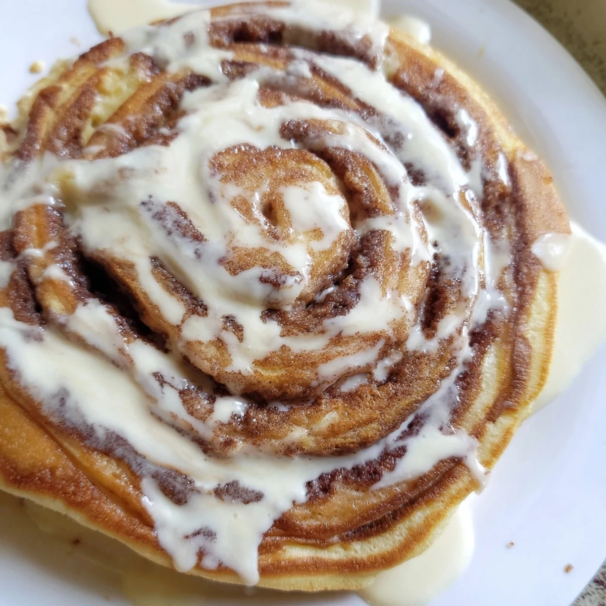 Fluffy pancakes spiraled with warm cinnamon sugar filling served on a white plate