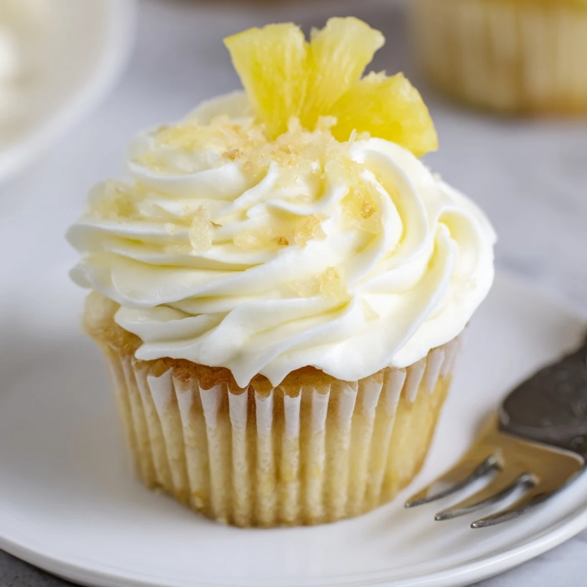 Dole Whip Cupcakes Recipe showing fluffy pineapple cupcakes topped with creamy frosting
