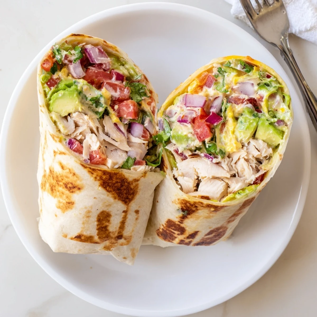 Golden skillet-toasted Chicken Avocado Ranch Burritos oozing creamy cheese and herbs