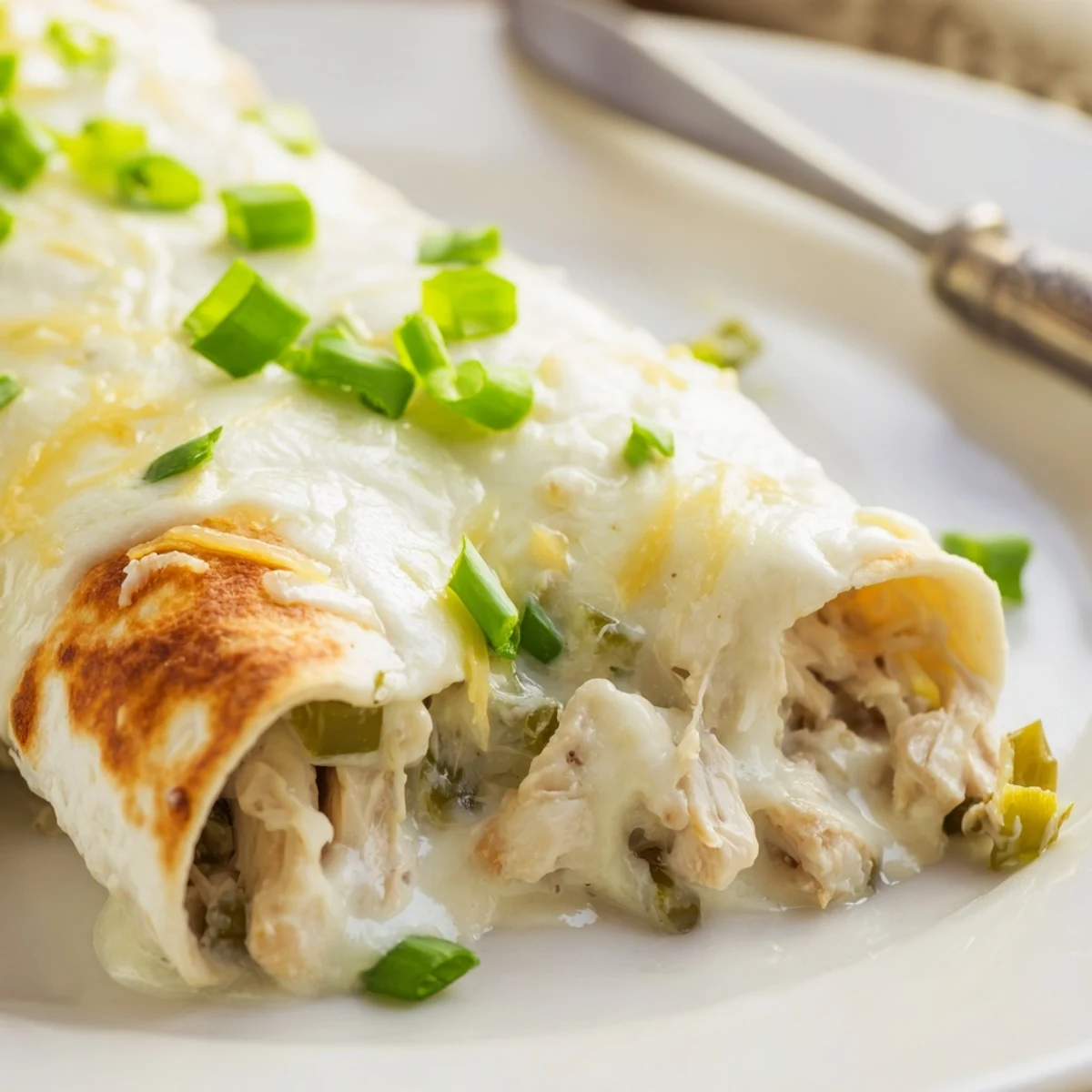 Casserole-style White Rotisserie Chicken Enchiladas in a baking dish, golden browned cheese