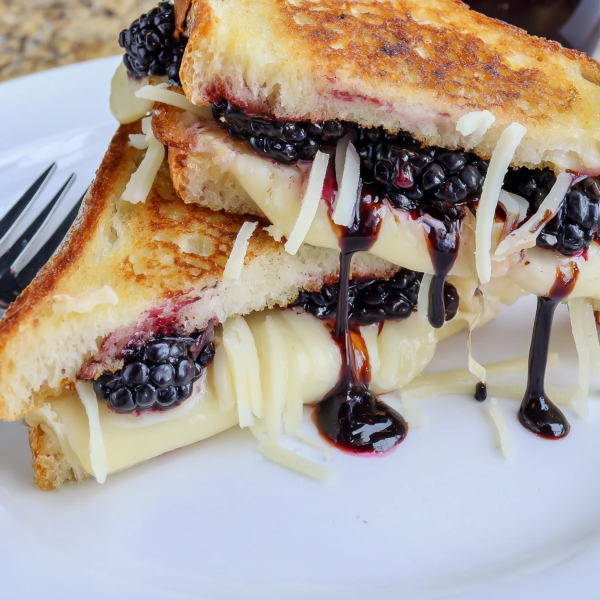 Golden, gooey Balsamic Blackberry Bliss Grilled Cheese topped with sweet-tangy glaze