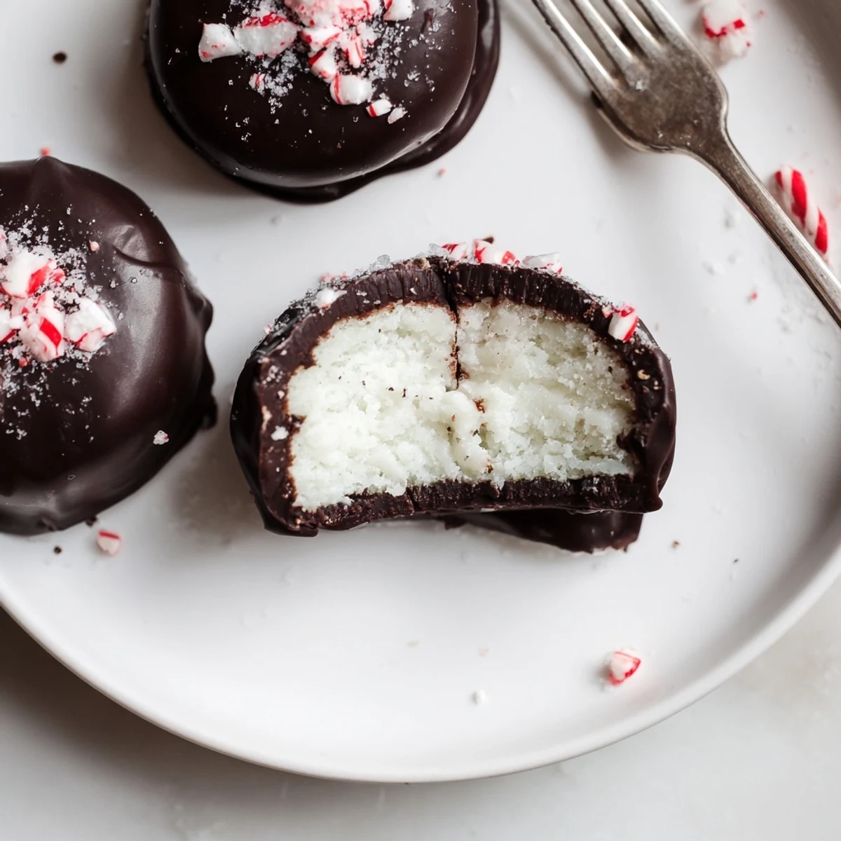 Peppermint Patties resting on parchment, glossy dark chocolate, cool minty filling.