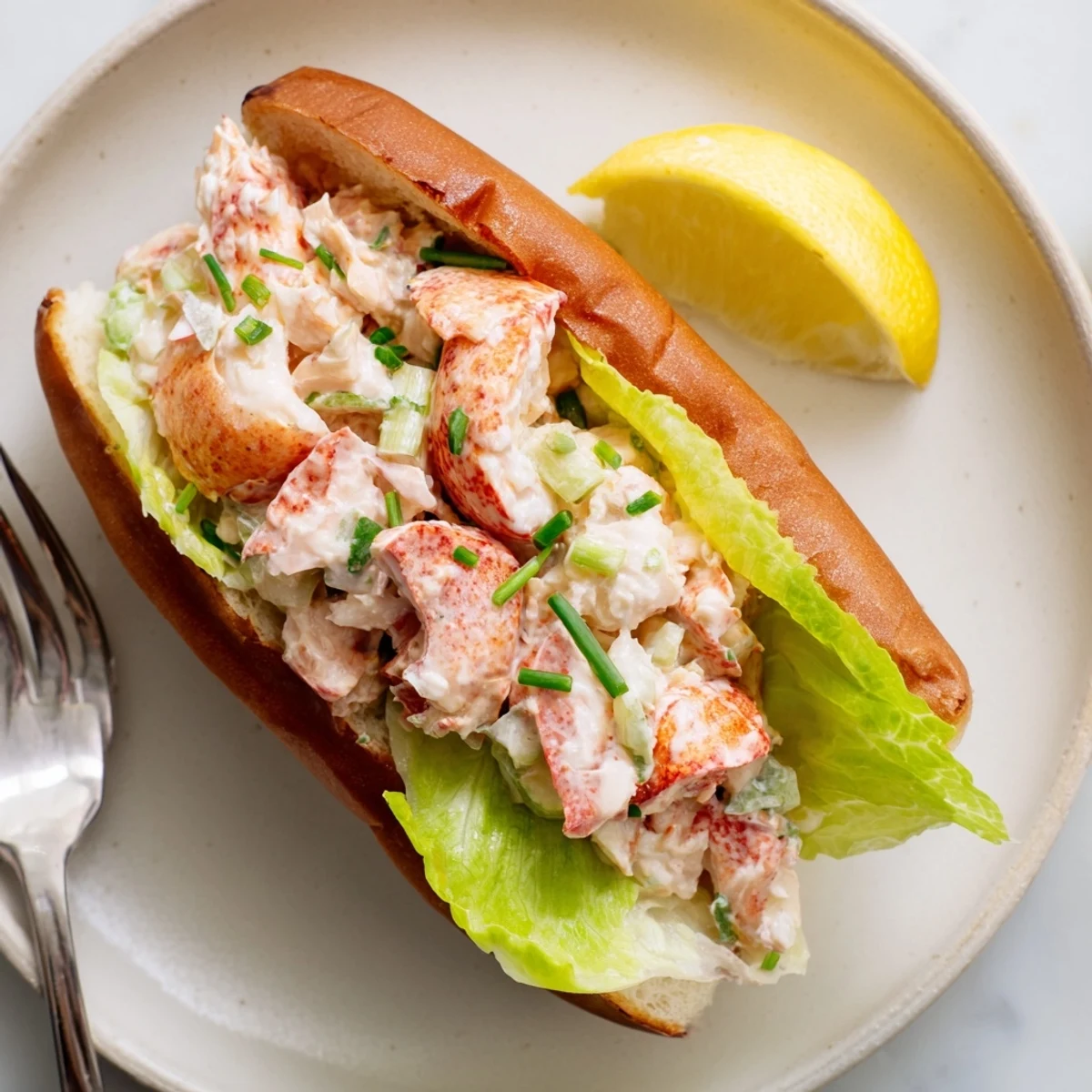Golden brown toasted split-top bun overflowing with sweet Maine style lobster rolls and fresh chives