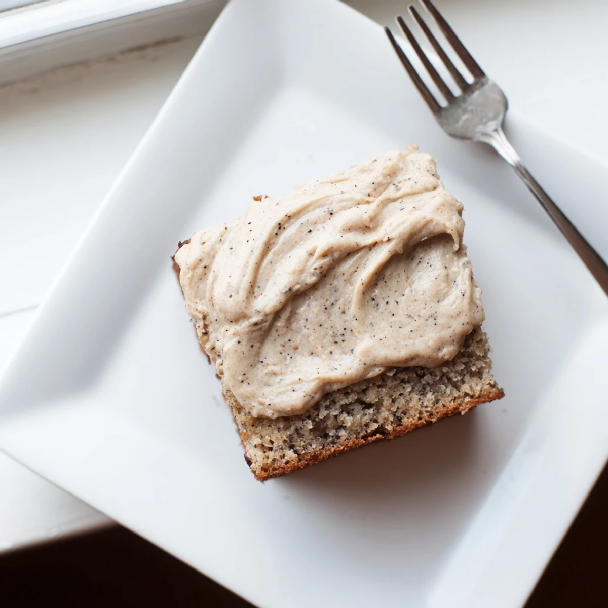 Golden frosted banana bread brownies with glossy brown butter icing atop moist texture