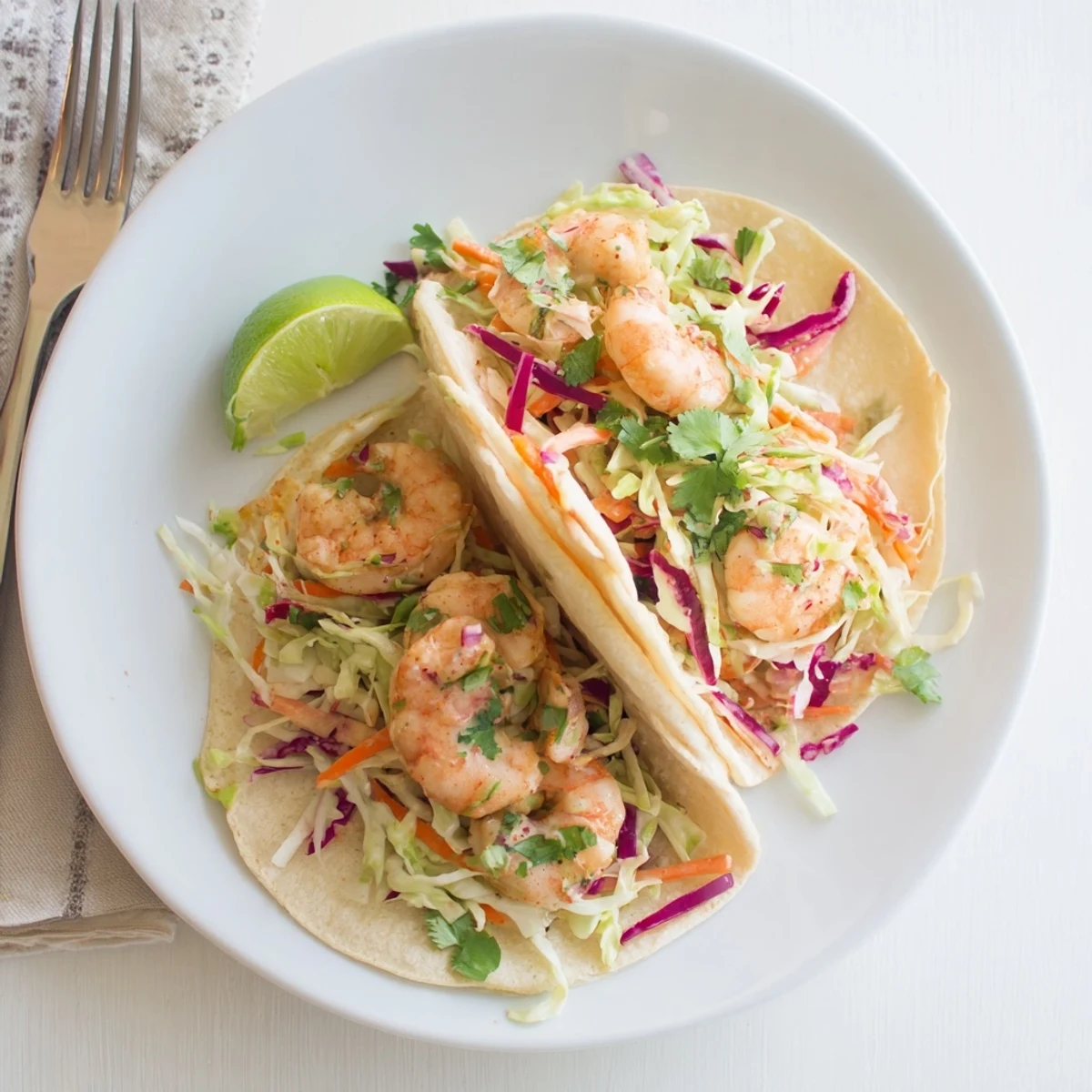 Golden shrimp tacos with slaw feature spiced juicy shrimp atop crisp colorful cabbage mixture in warm tortillas