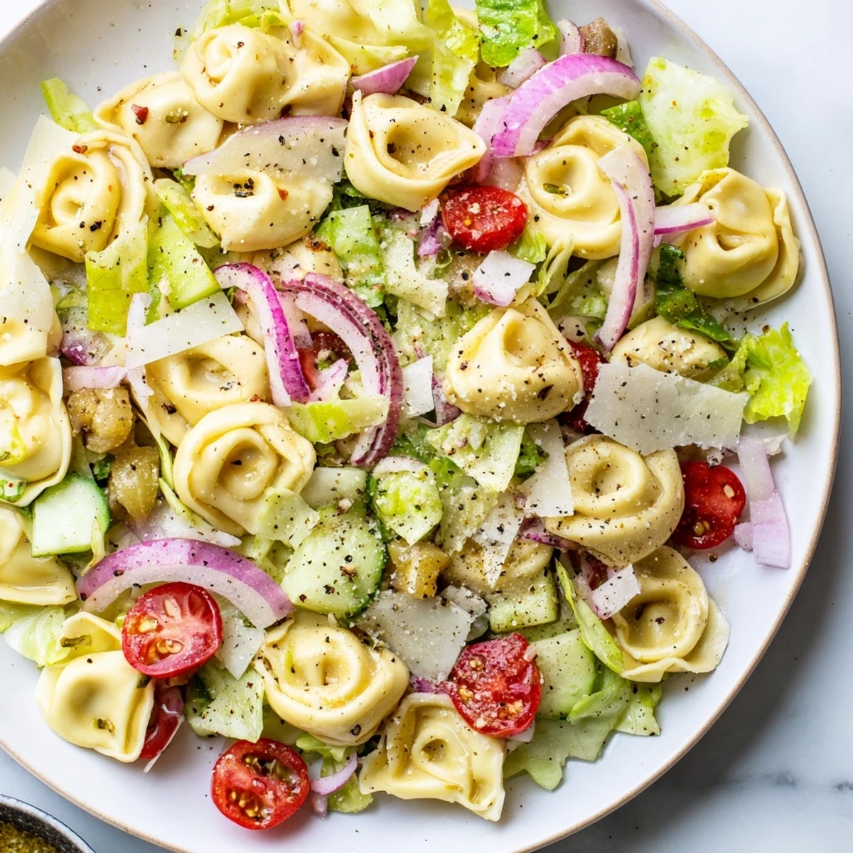 Colorful bowl of fresh grinder tortellini salad recipe with cherry tomatoes, provolone, and crisp vegetables