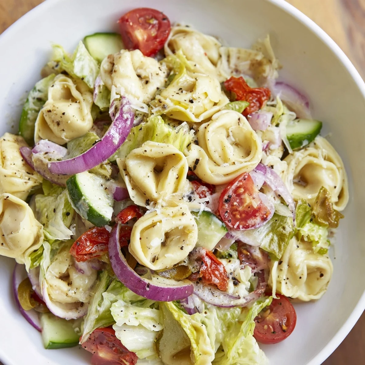 Hearty tortellini salad plated with red peppers, lettuce, and zesty Italian dressing for easy dinners