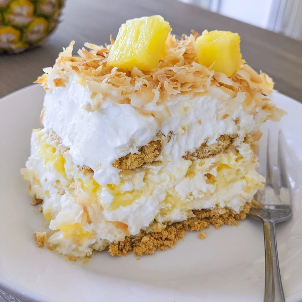 Fluffy No Bake Pineapple Coconut Cream Cake topped with toasted coconut shreds