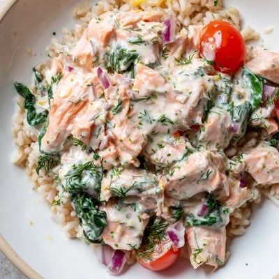 Healthy creamy leftover salmon recipe topped with fresh dill over a bed of whole wheat pasta